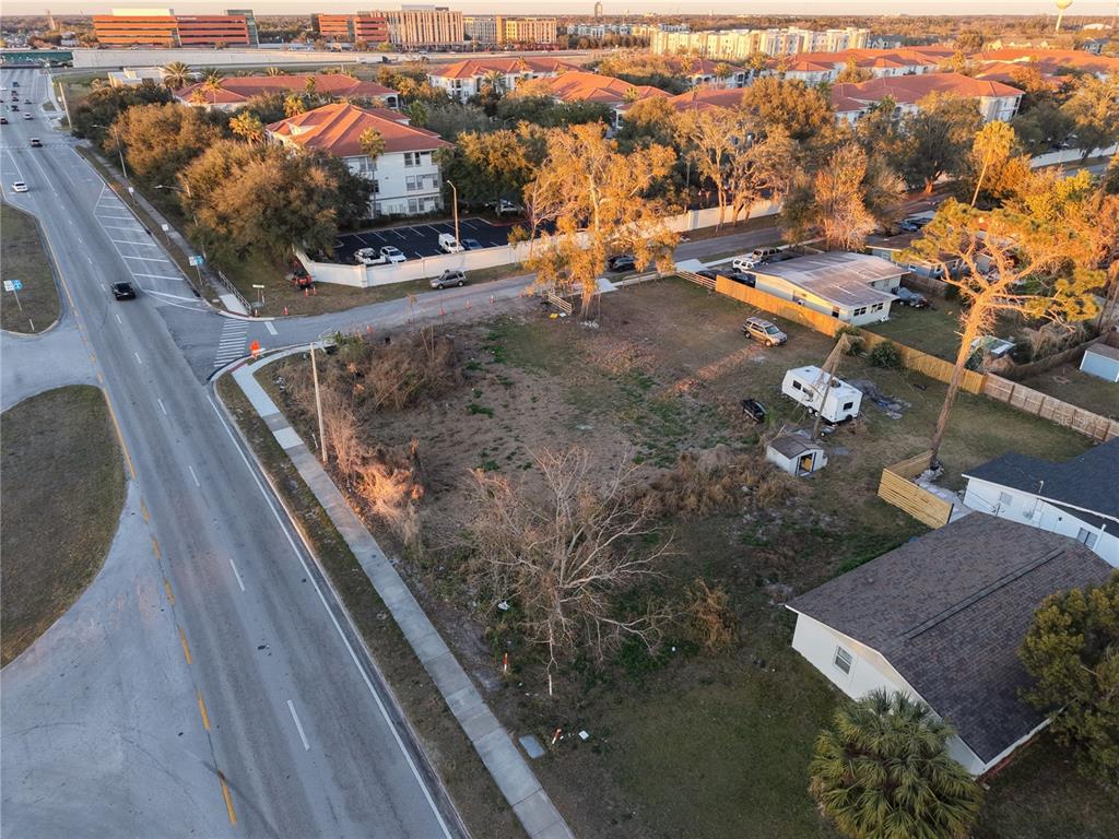 An aerial view shows a vacant lot situated next to a road and residential buildings — 2628 HERBISON DRIVE, ORLANDO, FL