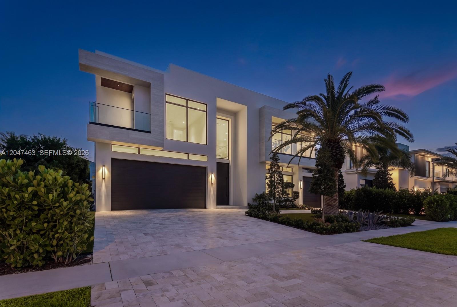 A modern two-story house features a white facade, a dark garage door, and a palm tree — 1051 NE 2nd Ter, Boca Raton FL 33432, BOCA RATON, FL