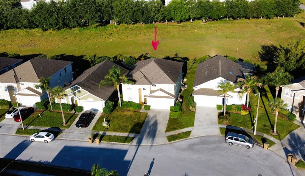 An aerial view shows a suburban street with several houses and a red arrow pointing down — 1821 MORNING STAR DRIVE, CLERMONT, FL