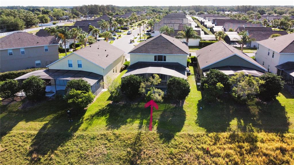 An aerial view shows the rear exterior of a suburban house with a screened-in patio — 1821 MORNING STAR DRIVE, CLERMONT, FL