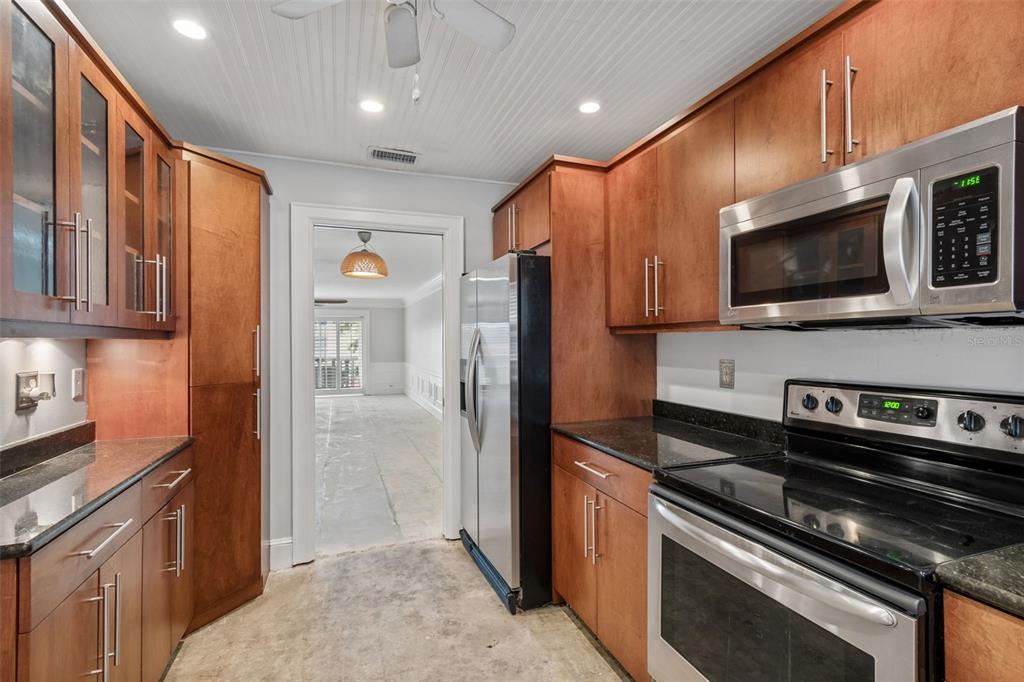 A kitchen with wood cabinets, stainless steel appliances, and a doorway leading to another room — 139 BLUFF VIEW DRIVE UNIT 110, LARGO, FL