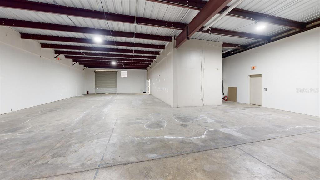 An empty industrial warehouse space features a concrete floor, white walls, and exposed steel beams — 605 NW 53RD AVENUE UNIT A-14, GAINESVILLE, FL