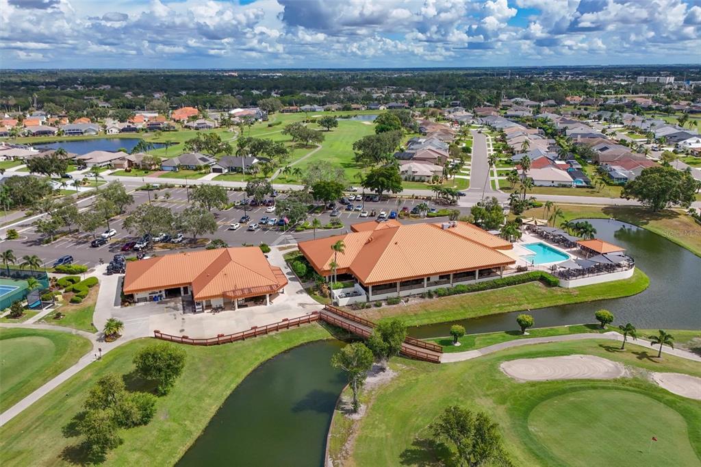 An aerial view shows a clubhouse complex with orange roofs, a pool, and golf course — 4427 MURFIELD DRIVE E, BRADENTON, FL