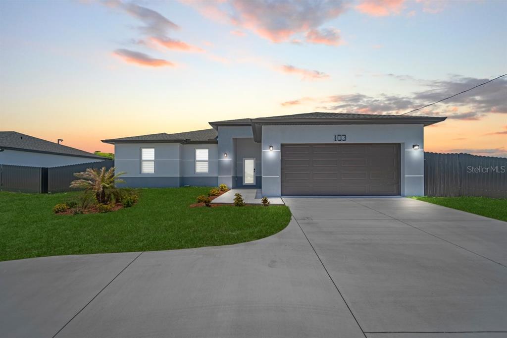A single-story house with a gray exterior, a two-car garage, and a concrete driveway — 103 DIPLOMAT PARKWAY E, CAPE CORAL, FL