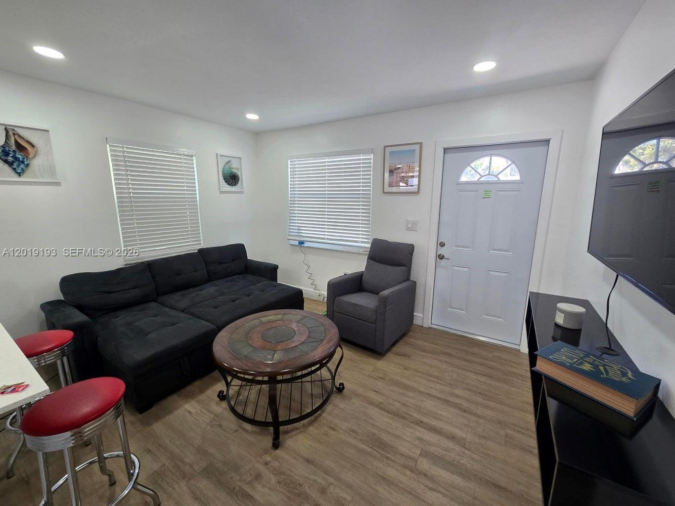 A living room features a black sectional sofa, a round coffee table, and a recliner — 37 Orange Dr, Key Largo FL 33037, KEY LARGO, FL