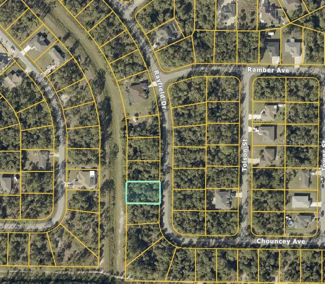 This is an aerial map showing a vacant, wooded residential lot highlighted in light blue — RAYFIELD DRIVE, NORTH PORT, FL