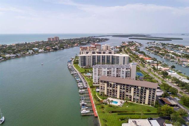 An aerial view of waterfront condominium buildings with a boat dock along a canal — 650 ISLAND WAY UNIT 708, CLEARWATER BEACH, FL