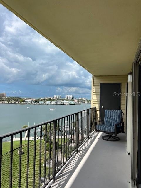 A balcony with a black metal railing overlooks a bay with boats and distant buildings — 650 ISLAND WAY UNIT 708, CLEARWATER BEACH, FL