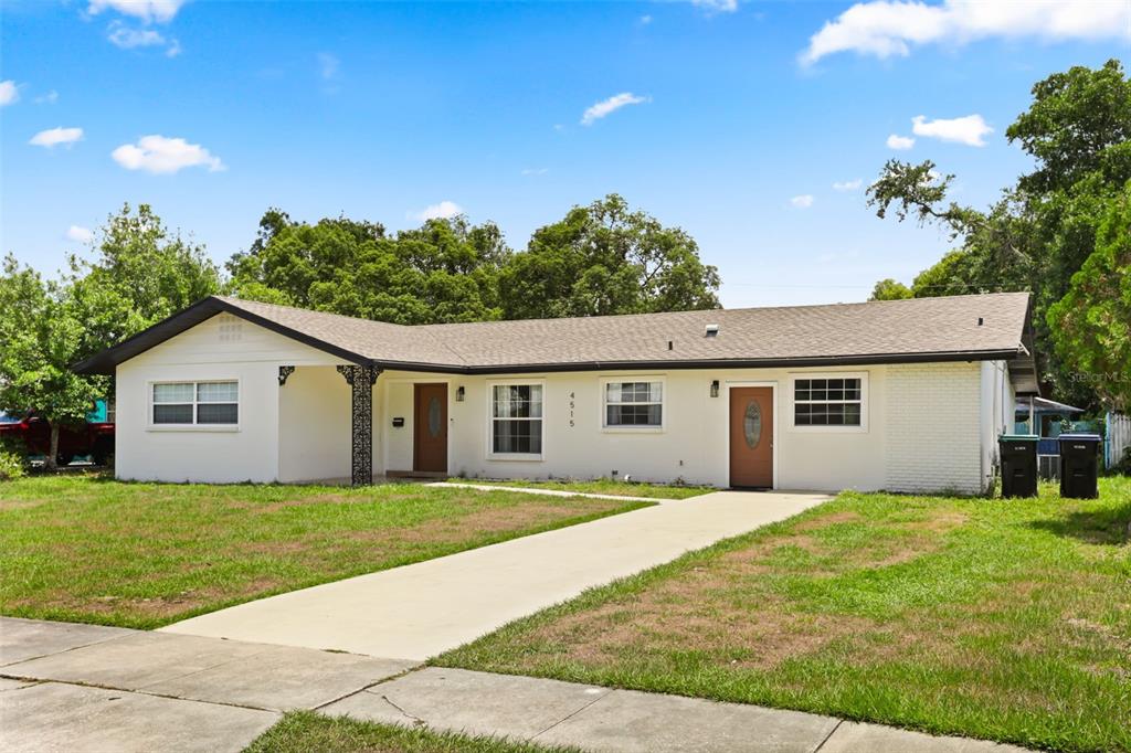 A single-story house with a white exterior, brown roof, and two front doors — 4515 BRADLEY AVENUE, ORLANDO, FL