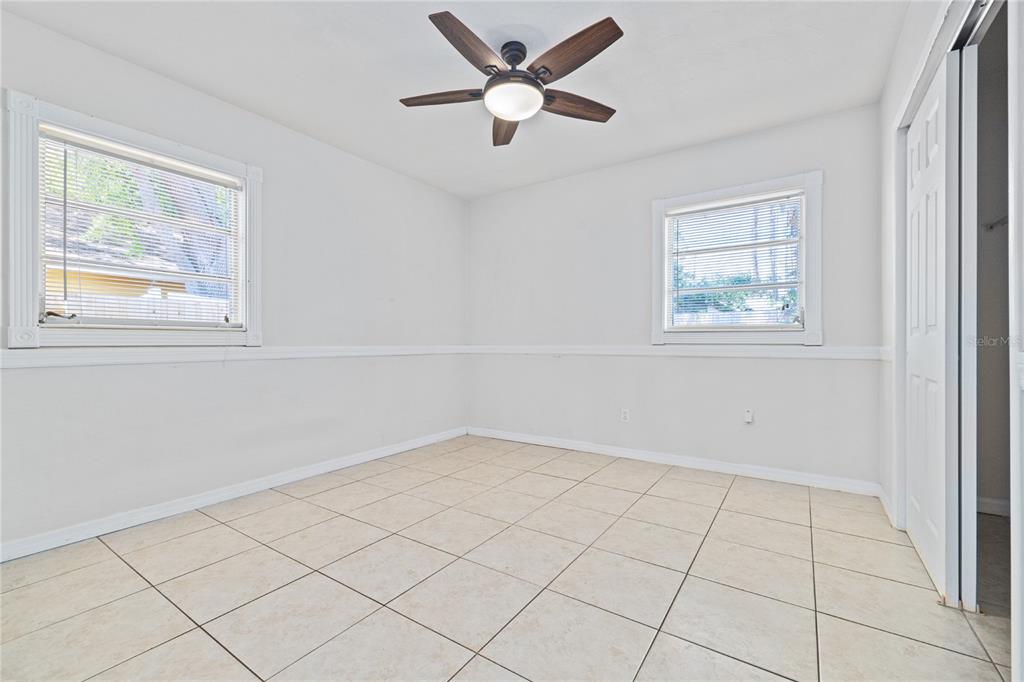An empty room with white walls, tile flooring, two windows, and a ceiling fan — 3005 W KATHLEEN STREET, TAMPA, FL