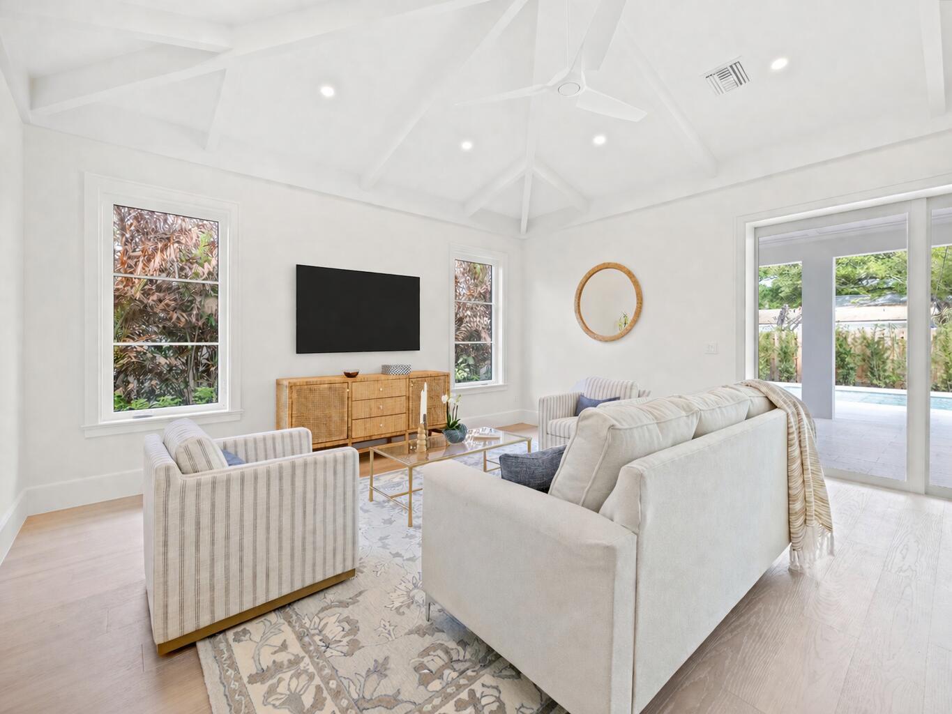 A bright living room features a vaulted ceiling, white walls, light wood floors, and furniture — 775 Acacia Road, Vero Beach FL 32963, VERO BEACH, FL