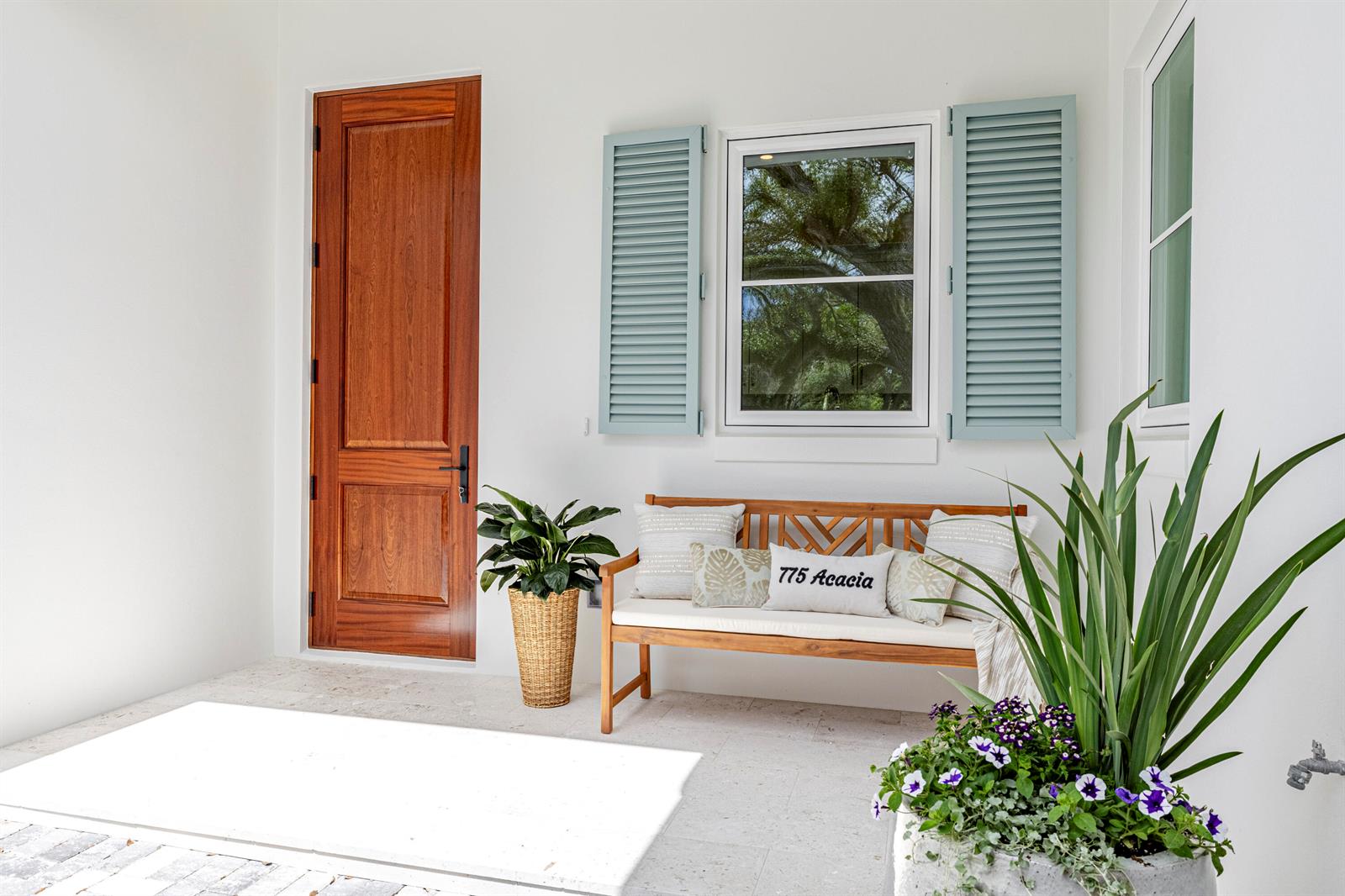 A wooden bench sits on a white porch next to a door and window — 775 Acacia Road, Vero Beach FL 32963, VERO BEACH, FL