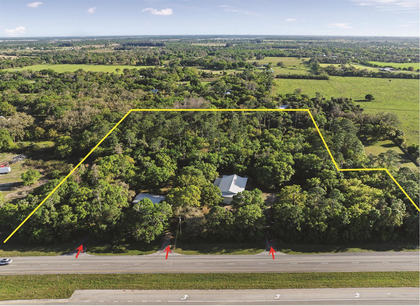 An aerial view shows a wooded property with two buildings and three driveway entrances — 11541 Okeechobee Road, Fort Pierce FL 34945, FORT PIERCE, FL