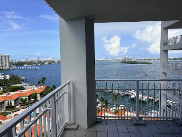 A balcony with a white railing overlooks a bay, a marina, and a distant city skyline — 4000 Towerside Ter # 1403, Miami FL 33138, MIAMI, FL