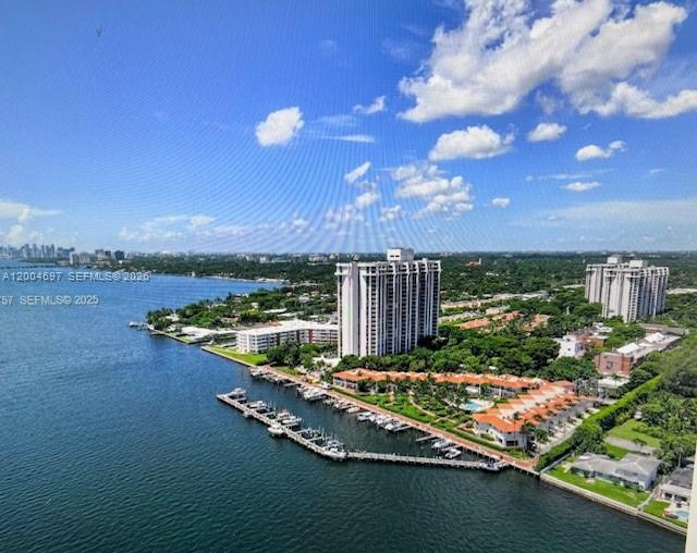 An aerial view shows a waterfront condominium complex with a marina and surrounding green space — 4000 Towerside Ter # 1403, Miami FL 33138, MIAMI, FL