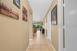 A tiled hallway leads to a living area with a view of the outdoors — 5147 WILLOW LINKS UNIT 18, SARASOTA, FL