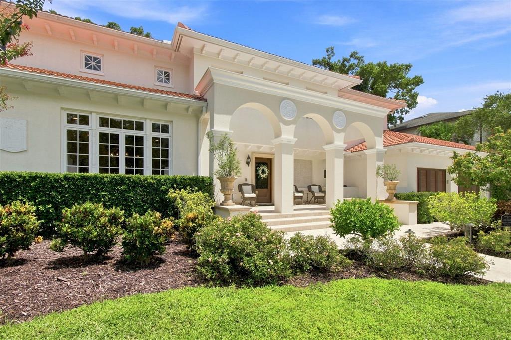 A single-story house with a stucco exterior, arched entryway, and a red tile roof — 4537 W SWANN AVENUE, TAMPA, FL