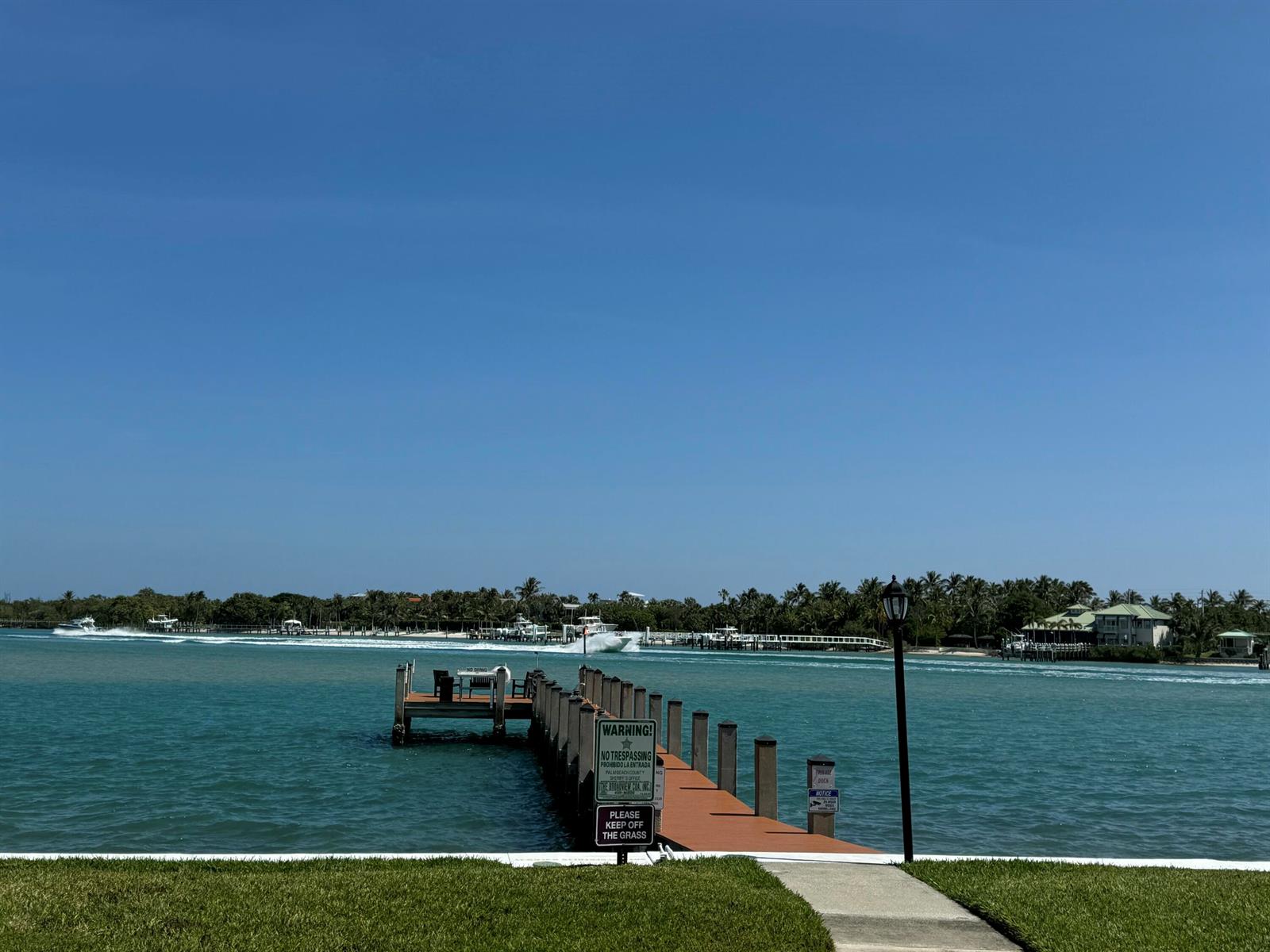 A wooden dock extends into a blue waterway under a clear sky — 200 Intracoastal Place # 404, Jupiter FL 33469, JUPITER, FL