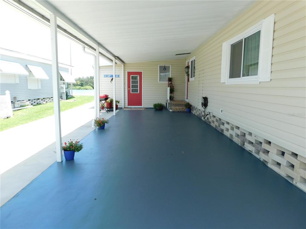 A single-story mobile home with beige siding, a carport, and a red front door — 4619 15TH STREET COURT E, ELLENTON, FL