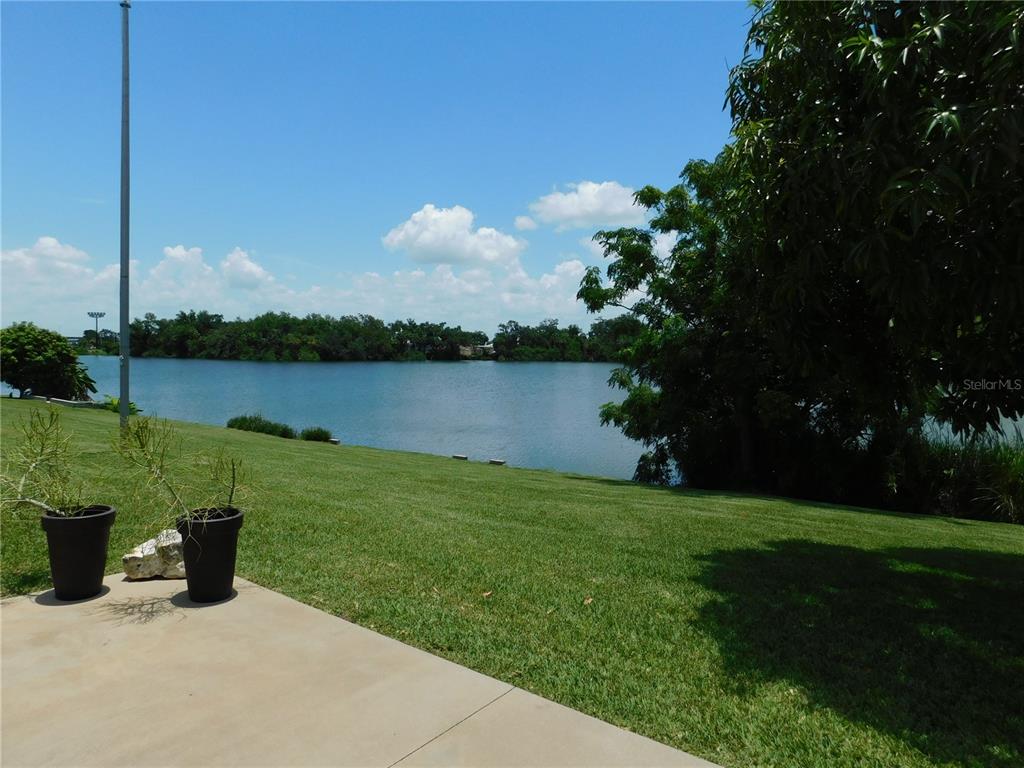 An open-concept living room and kitchen with light wood flooring and a central island — 4619 15TH STREET COURT E, ELLENTON, FL