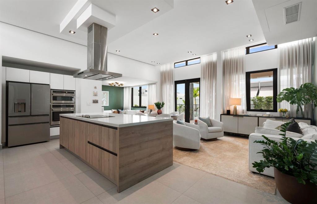 A modern open-concept kitchen and living area with a wood-paneled island and high ceilings — Ebro 68, BAYAMON, PR