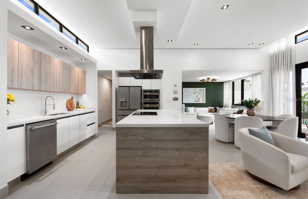 A modern kitchen features a wood-paneled island, white cabinetry, stainless steel appliances, and recessed lighting — Ebro 68, BAYAMON, PR