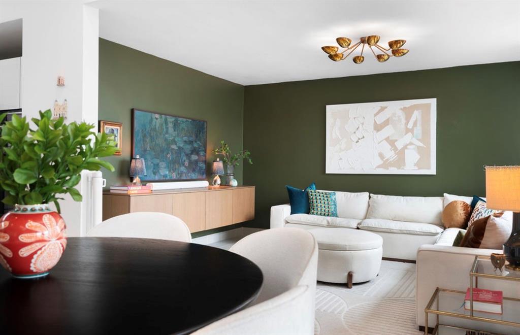 A dining area with a round table opens into a living room with olive green walls — Ebro 68, BAYAMON, PR