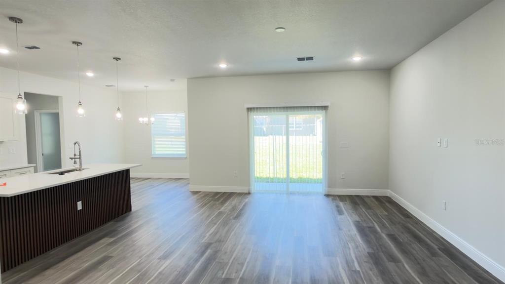 A kitchen with a dark wood island and a dining area with sliding glass doors — 4522 SW 170TH STREET ROAD, OCALA, FL