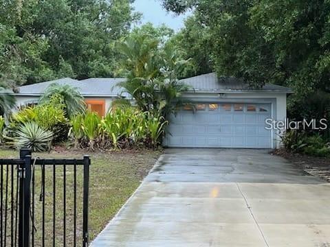A single-story house with a light-colored exterior, a two-car garage, and a concrete driveway — 895 KEEN ROAD, FROSTPROOF, FL