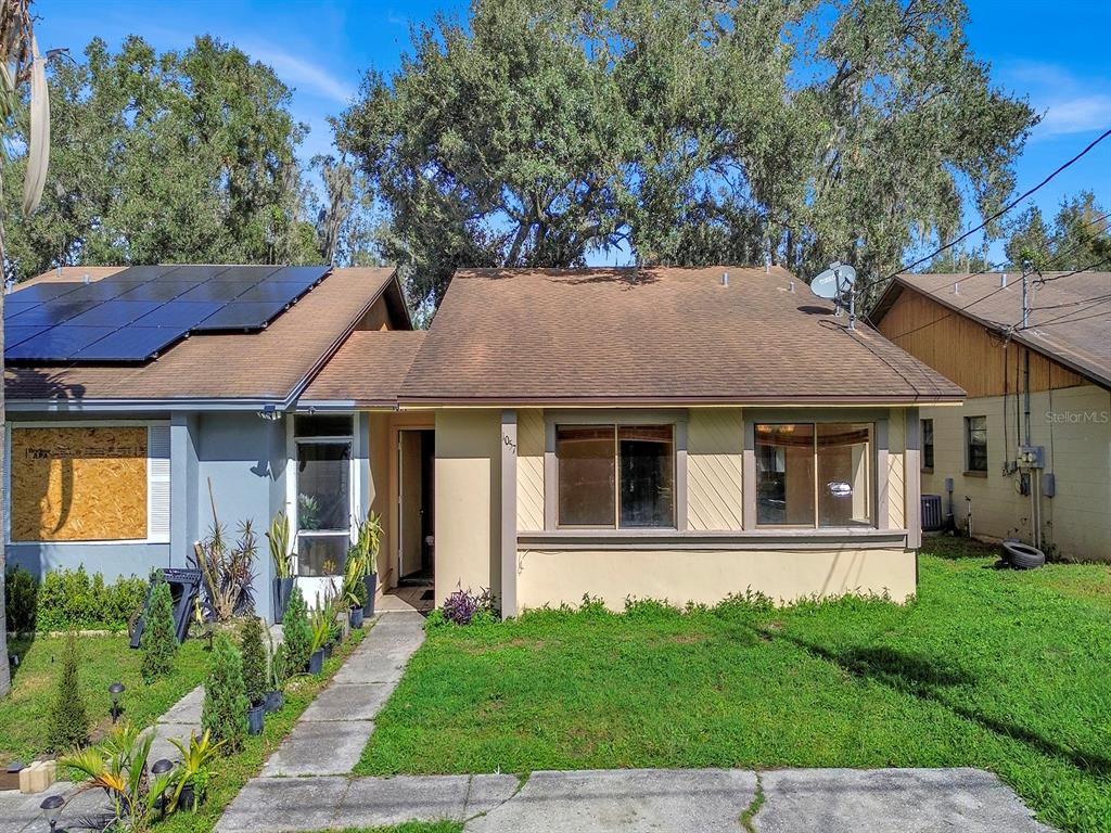 A single-story house with a brown shingled roof, solar panels, and a front lawn — 1057 OLD SOUTH DRIVE, LAKELAND, FL