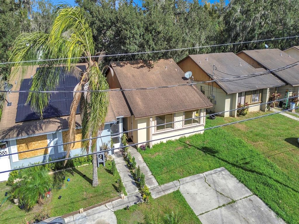 An aerial view shows two adjacent single-story houses with brown roofs and a palm tree — 1057 OLD SOUTH DRIVE, LAKELAND, FL