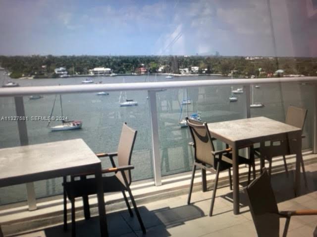 A balcony with two dining tables and chairs overlooks a bay filled with sailboats — 777 N Ocean Dr # S333, Hollywood FL 33019, HOLLYWOOD, FL