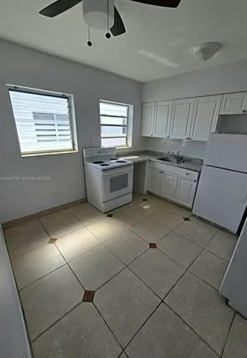 A kitchen features white cabinets, a white stove, a white refrigerator, and tiled flooring — 1420 NE 171st St # 2, North Miami Beach FL 33162, NORTH MIAMI BEACH, FL