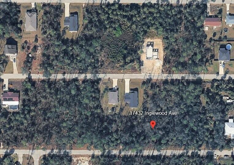 This aerial view shows a residential lot with dense trees and nearby houses — 17432 INGLEWOOD AVENUE, PORT CHARLOTTE, FL