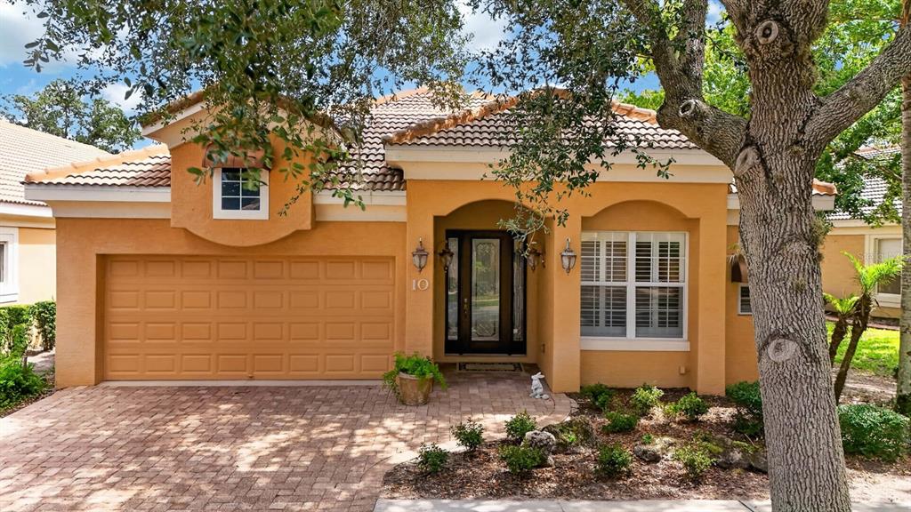 A single-story orange stucco house features a two-car garage, a tiled roof, and a front entryway — 10 LAKESIDE WAY, PALM COAST, FL
