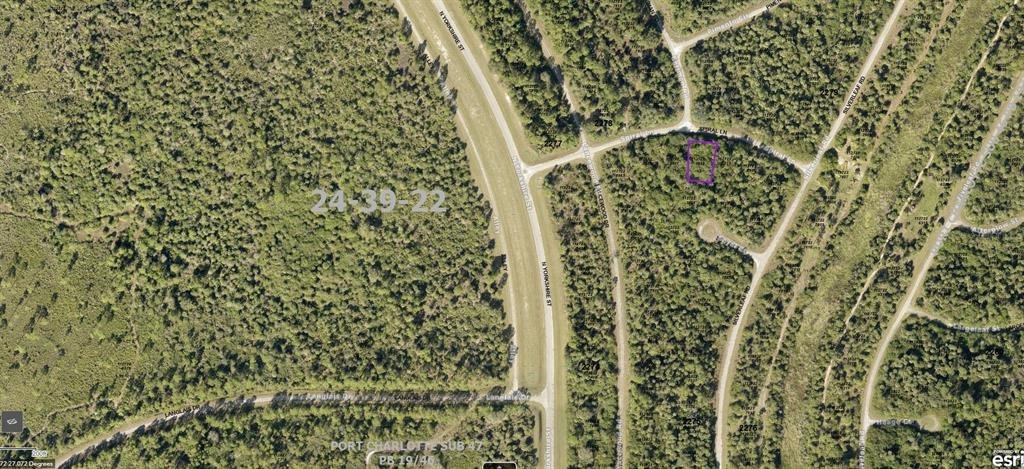 An aerial map view showing a vacant, rectangular lot outlined in purple within a wooded area — 1127227518 SPIRAL LANE, NORTH PORT, FL