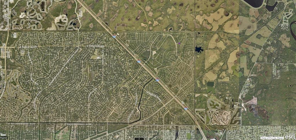 This is an aerial map view of a residential neighborhood divided by a highway — 1127227518 SPIRAL LANE, NORTH PORT, FL