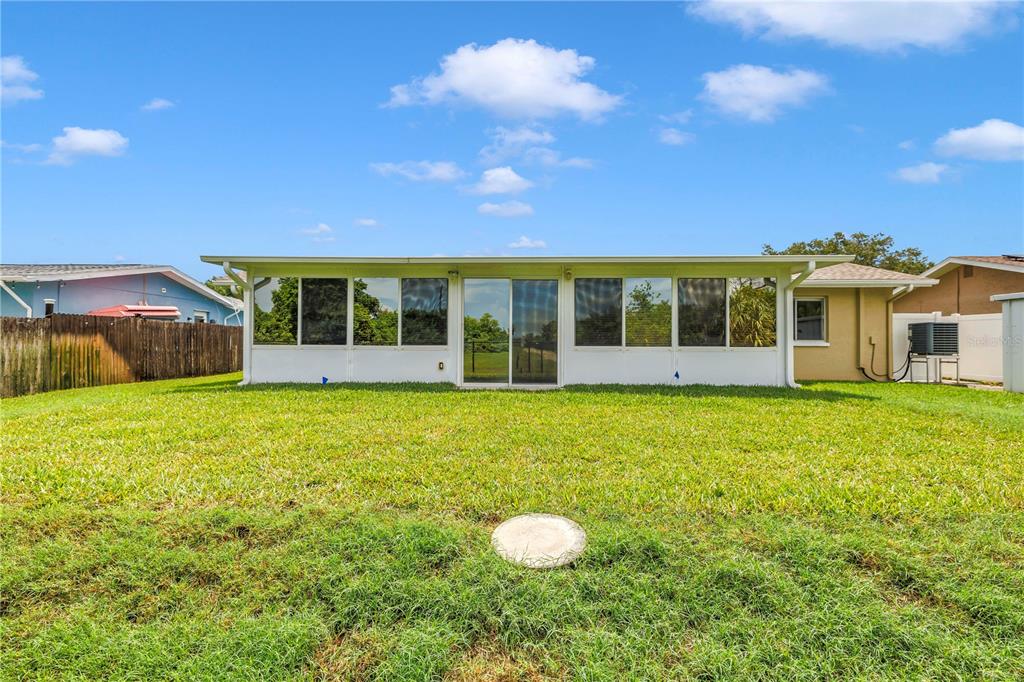 An aerial view shows a house with a shingled roof, paved driveway, and backyard lawn — 5812 16TH LANE NE, ST PETERSBURG, FL