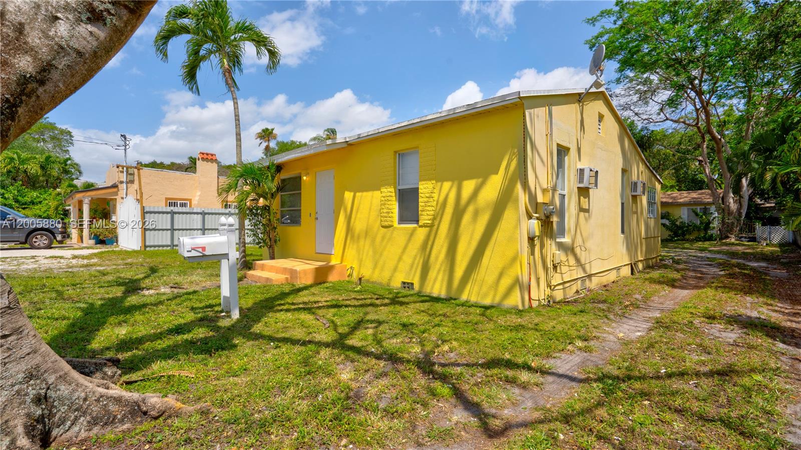 A yellow, single-story house with a white door and a mailbox in the front yard — 1085 NE 128th St, North Miami FL 33161, NORTH MIAMI, FL