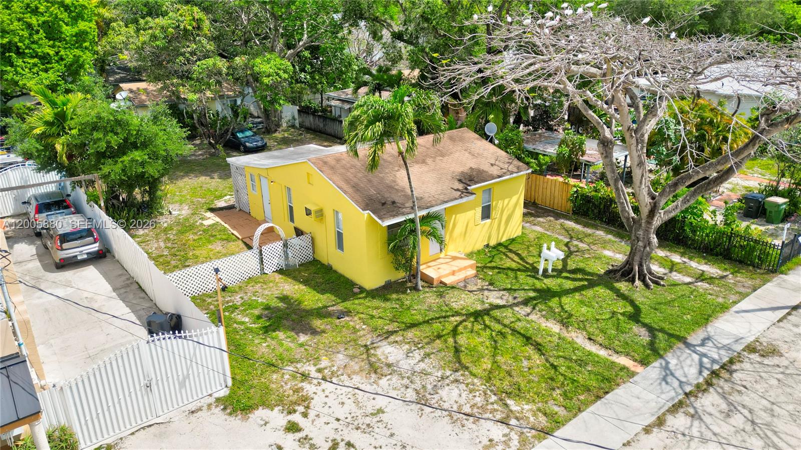 An aerial view shows a small yellow house with a brown roof and a yard — 1085 NE 128th St, North Miami FL 33161, NORTH MIAMI, FL