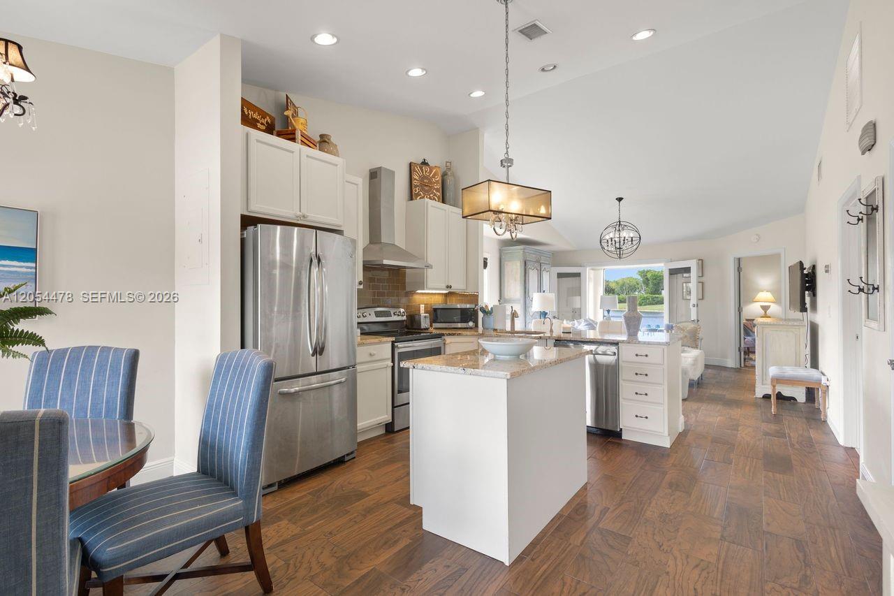 A kitchen with white cabinets, stainless steel appliances, and a granite-topped island — 18551 Woodstream Dr, Boca Raton FL 33498, BOCA RATON, FL