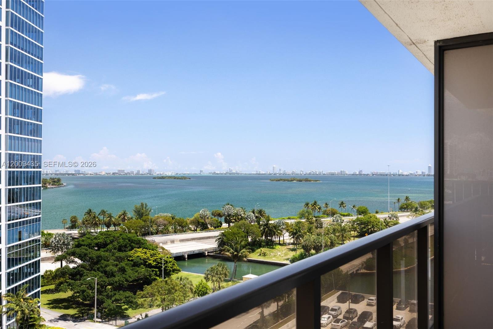 A high-rise balcony overlooks a bay, a highway, and a distant city skyline — 600 NE 36th St # 1109, Miami FL 33137, MIAMI, FL