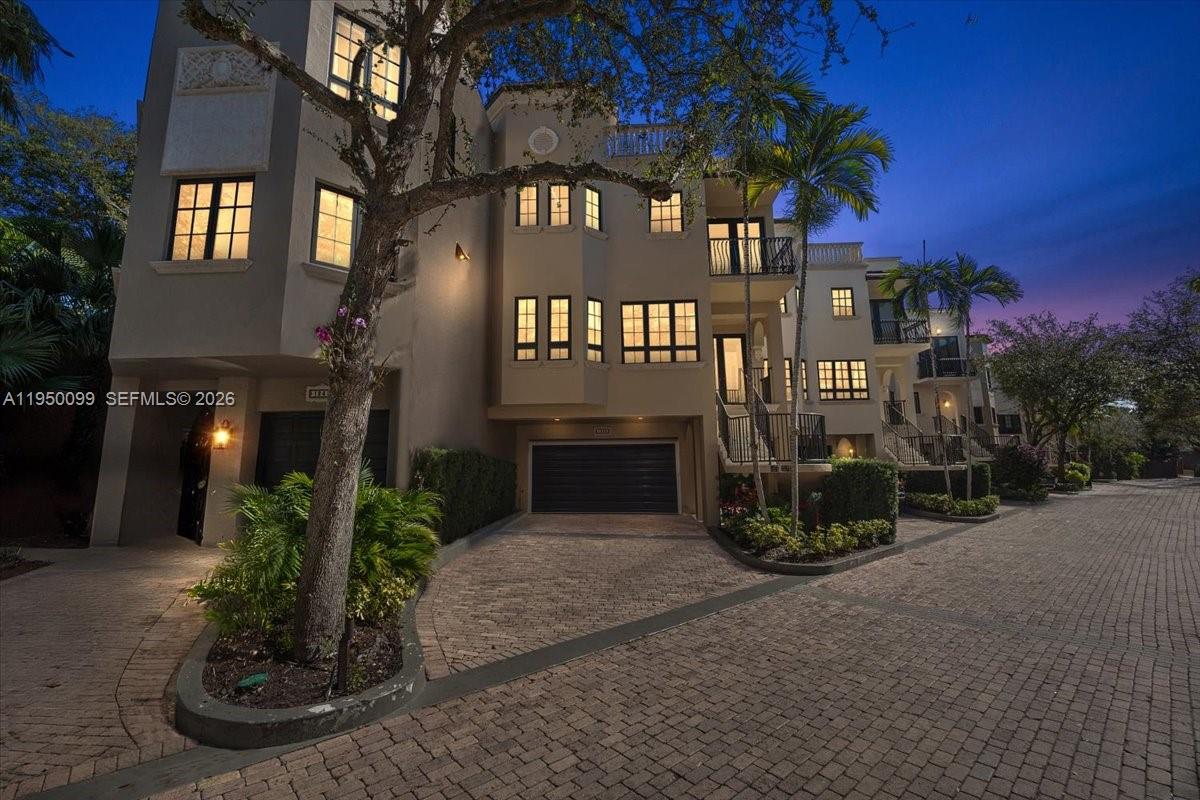A multi-story residential building with a paved driveway and attached garage at dusk — 3471 Main Hwy # 1240, Miami FL 33133, MIAMI, FL