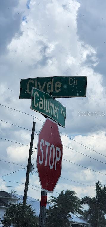 A street sign for Clyde Cir and Calumet Blvd stands above a red stop sign — 8175 CLYDE CIRCLE, PORT CHARLOTTE, FL