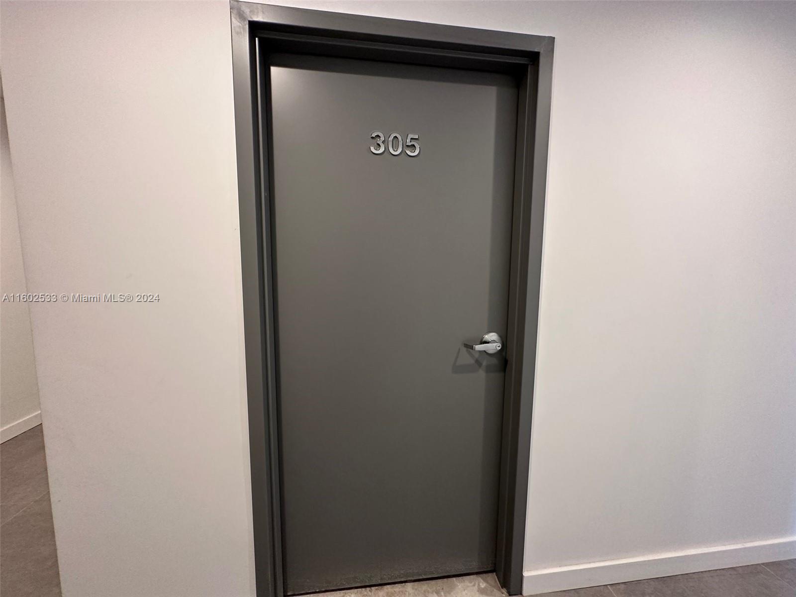 A gray door with the number 305 is set in a plain white wall — 42 NW 27th Ave # 305, Miami FL 33125, MIAMI, FL