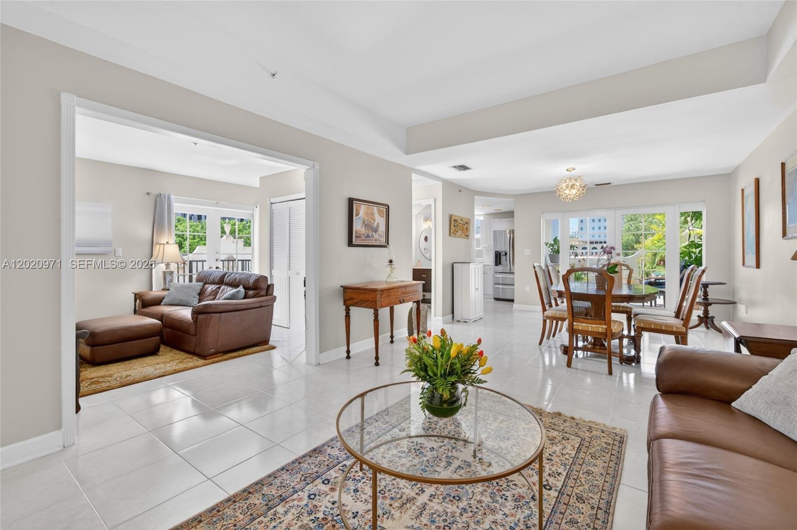 A bright, open-concept living and dining area features tile flooring and neutral walls — 323 Navarre Ave # 403, Coral Gables FL 33134, CORAL GABLES, FL