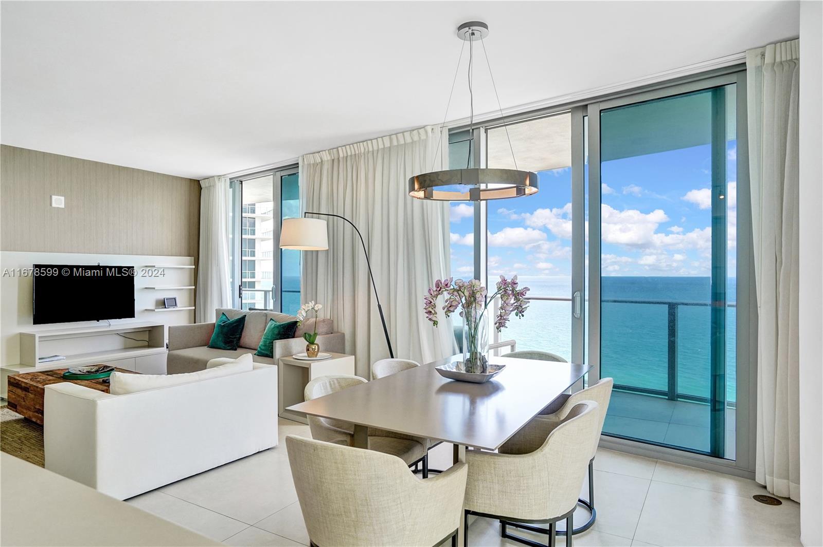 A modern living and dining area features floor-to-ceiling windows with an ocean view — 4111 S Ocean Dr # 1201, Hollywood FL 33019, HOLLYWOOD, FL