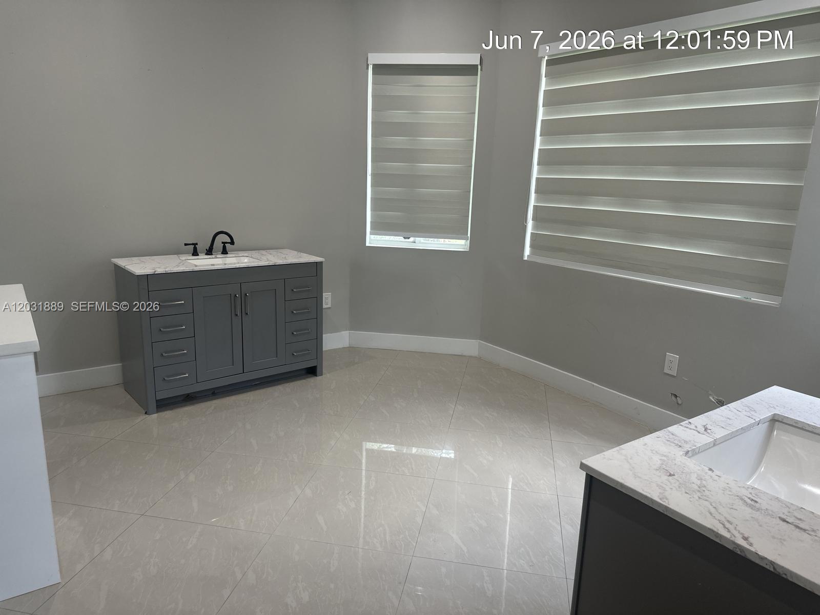 A bathroom features two gray vanities with marble countertops and light-colored tile flooring — 1974 SE 23rd Ct, Homestead FL 33035, HOMESTEAD, FL
