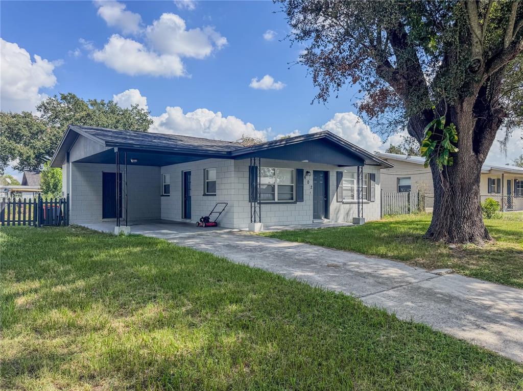 A single-story concrete block house with a carport, a driveway, and a large oak tree — 602 TAYLOR BOULEVARD, WINTER HAVEN, FL