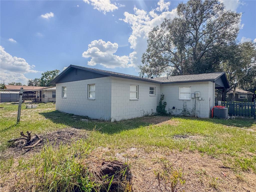 The exterior of a gray concrete block house with a dark roof and yard — 602 TAYLOR BOULEVARD, WINTER HAVEN, FL